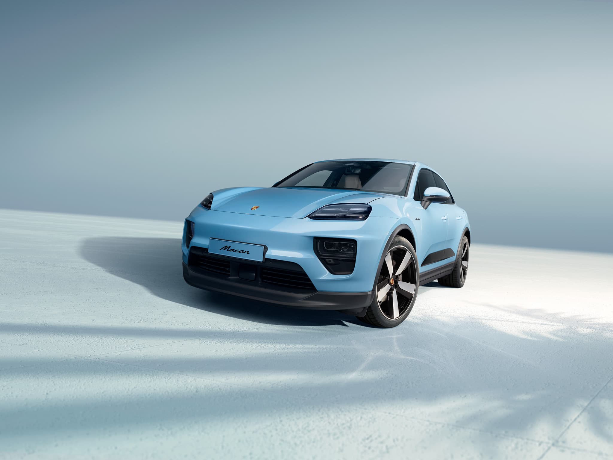 Une Porsche Macan circulant sur une route ouverte.